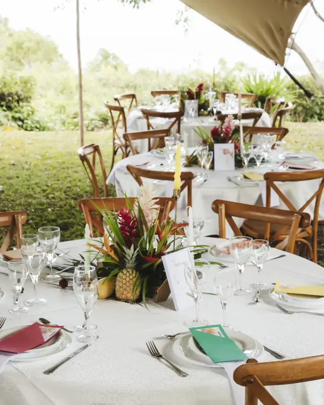 Tables rondes dressées dans le jardin pour une réception